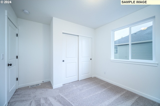 unfurnished bedroom with carpet and a closet