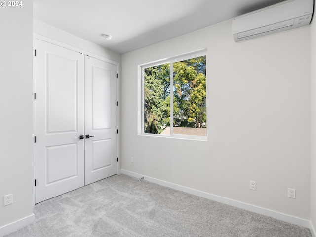 7471 N New York Ave Unit 3, Portland, OR 97203 - unfurnished bedroom featuring baseboards, a wall mounted AC, a closet, and carpet