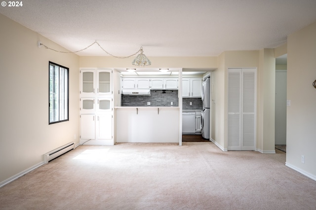 kitchen with a baseboard radiator, white dishwasher, white cabinets, stainless steel fridge, and light colored carpet