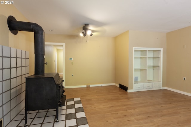 workout area with a wood stove and light hardwood / wood-style floors