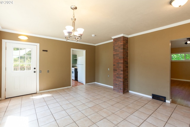 interior space featuring decorative columns, light tile patterned floors, crown molding, and a chandelier