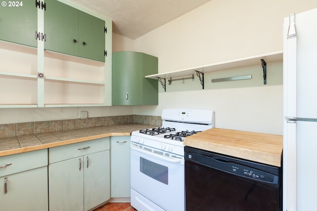 kitchen with tile countertops, green cabinets, white appliances, and light tile patterned floors