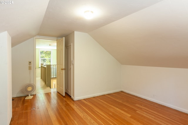 bonus room featuring lofted ceiling and light wood-type flooring