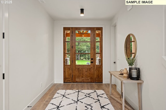 foyer featuring light wood-type flooring and baseboards