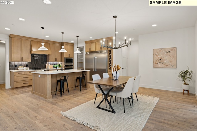 dining space with recessed lighting, baseboards, and light wood finished floors