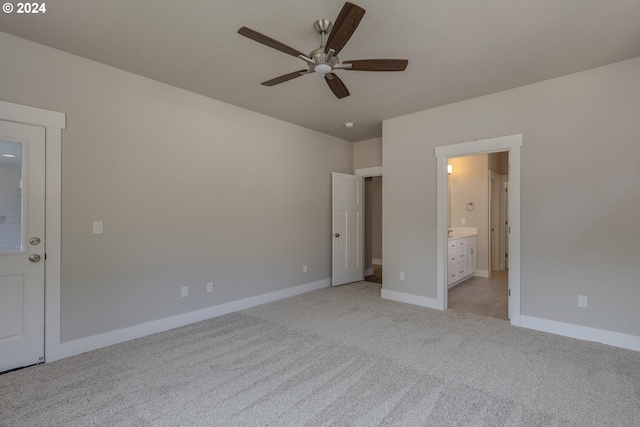 unfurnished bedroom with ceiling fan, light colored carpet, and connected bathroom