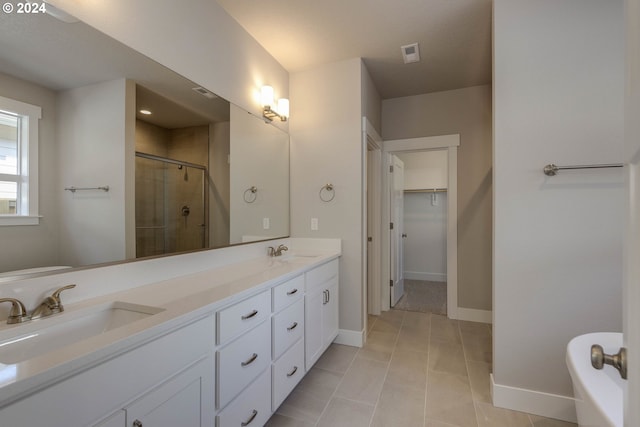 bathroom with tile patterned flooring, vanity, and a shower with shower door