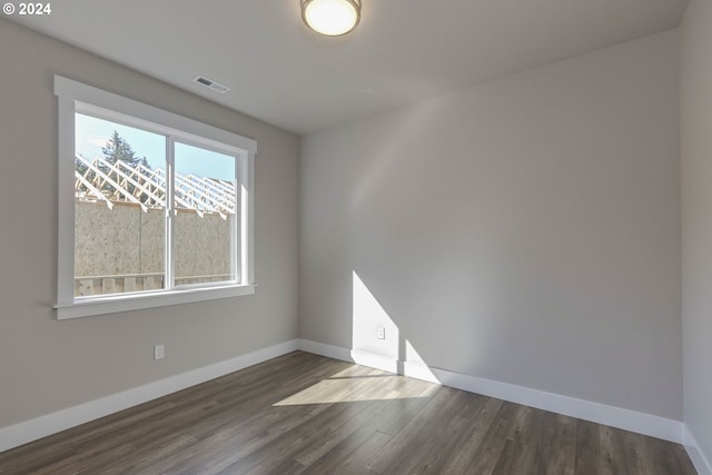 spare room with dark hardwood / wood-style flooring