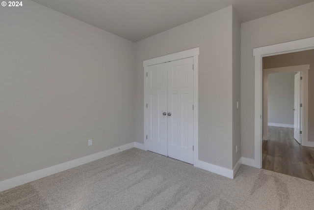 unfurnished bedroom featuring carpet flooring and a closet