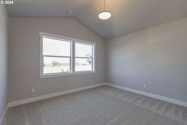 carpeted empty room featuring vaulted ceiling