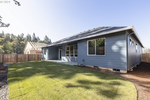 back of house with a yard and a patio