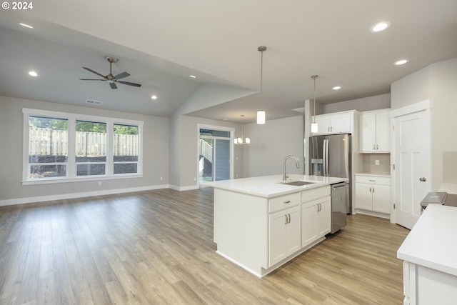 kitchen with pendant lighting, white cabinets, sink, an island with sink, and appliances with stainless steel finishes