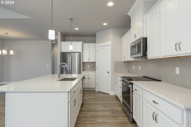 kitchen with white cabinetry, an island with sink, stainless steel appliances, and decorative light fixtures