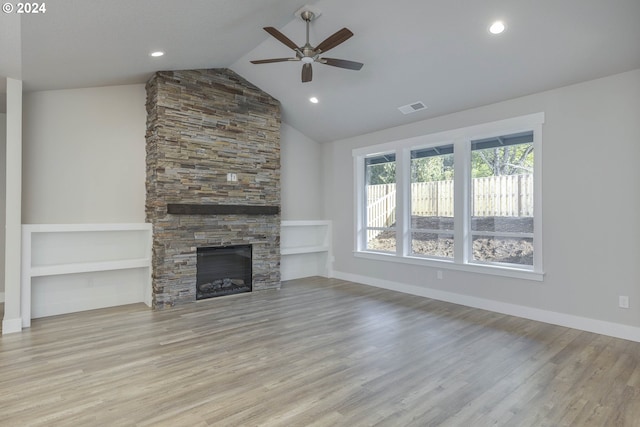 unfurnished living room featuring ceiling fan, built in features, high vaulted ceiling, light hardwood / wood-style flooring, and a stone fireplace