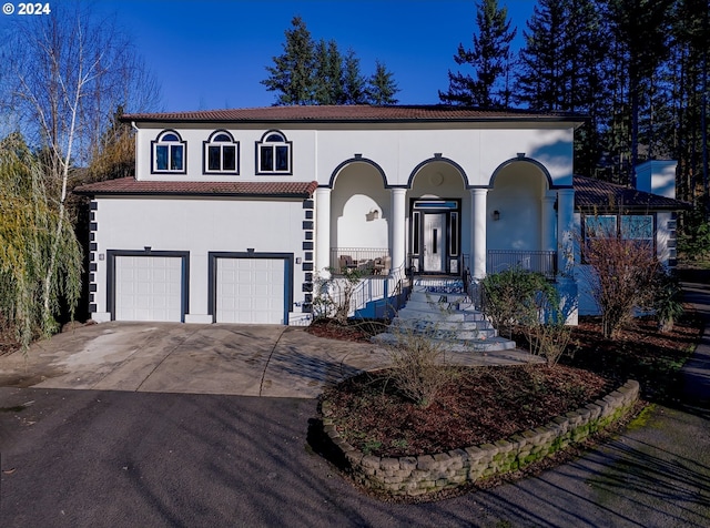 mediterranean / spanish house featuring a porch and a garage