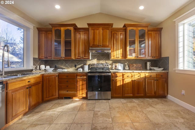 kitchen featuring light stone countertops, backsplash, stainless steel appliances, sink, and lofted ceiling