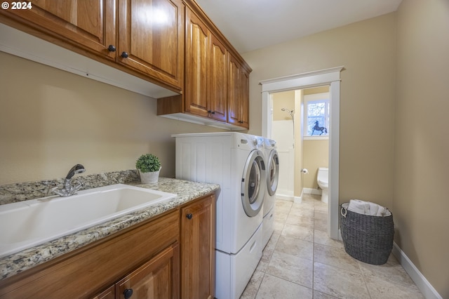 clothes washing area with cabinets, light tile patterned floors, separate washer and dryer, and sink