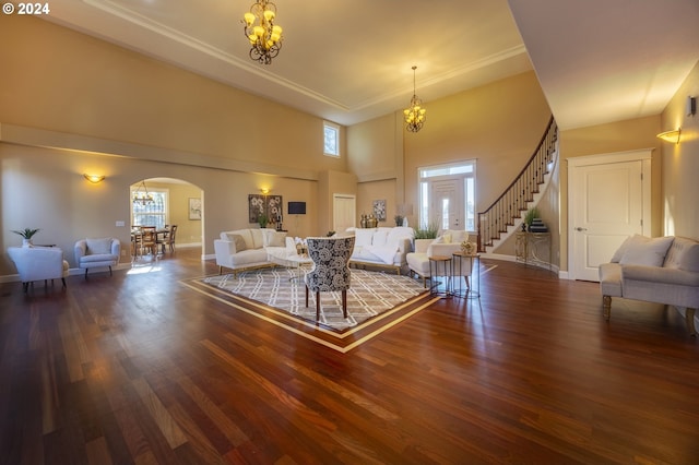 living room with a chandelier, a high ceiling, dark hardwood / wood-style flooring, and a healthy amount of sunlight