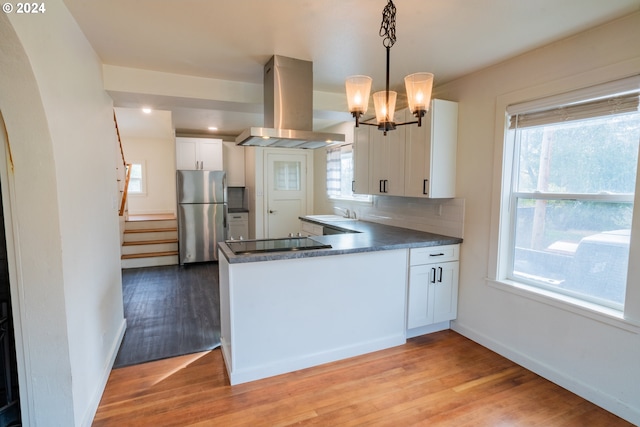 410 N Mountain Blvd, Mount Vernon, OR 97865 - kitchen with freestanding refrigerator, dark countertops, black electric stovetop, island range hood, and light wood finished floors