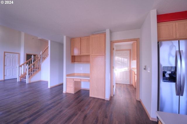 kitchen featuring light brown cabinets, stainless steel refrigerator with ice dispenser, built in desk, and dark wood-type flooring