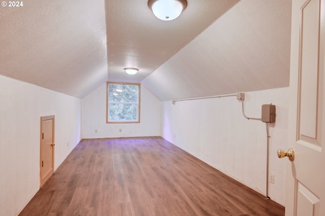 bonus room with vaulted ceiling, hardwood / wood-style floors, and a textured ceiling