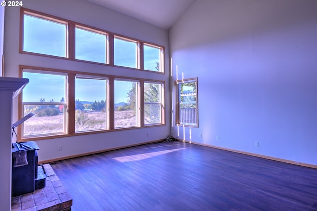 unfurnished living room with dark hardwood / wood-style floors and high vaulted ceiling