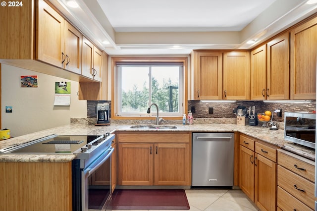 kitchen featuring backsplash, sink, stainless steel appliances, light tile floors, and light stone counters