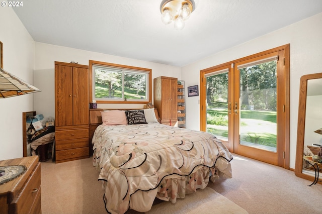 carpeted bedroom featuring french doors, access to exterior, and multiple windows