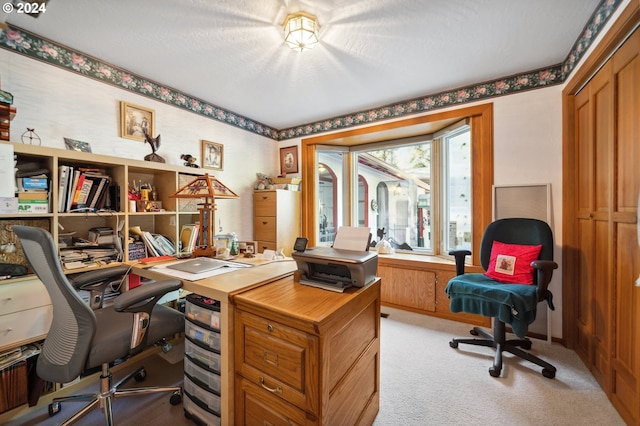 carpeted home office with a textured ceiling