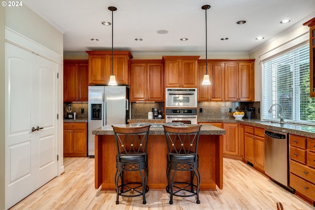 kitchen featuring decorative light fixtures, a center island, and appliances with stainless steel finishes