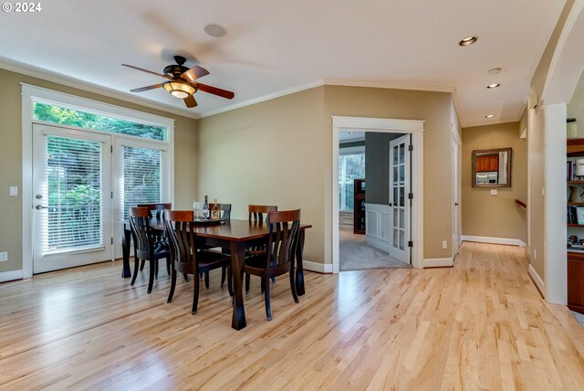 dining room with crown molding, light hardwood / wood-style flooring, and a wealth of natural light