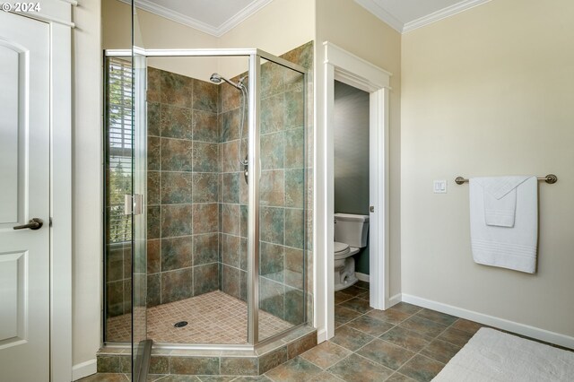 bathroom featuring crown molding, a shower with shower door, and toilet