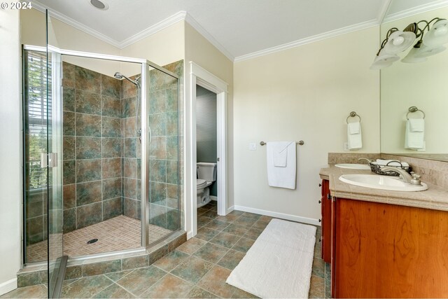 bathroom featuring ornamental molding, toilet, an enclosed shower, and vanity