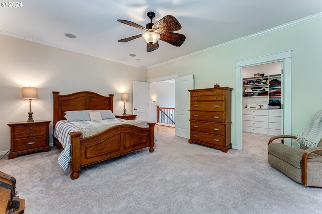 bedroom featuring ceiling fan, ornamental molding, light carpet, a spacious closet, and a closet