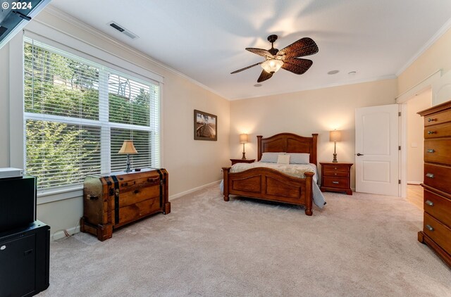 bedroom featuring light colored carpet, ornamental molding, and ceiling fan