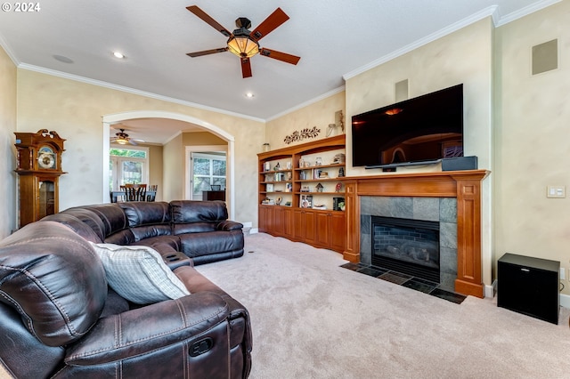 living room with ornamental molding, carpet flooring, ceiling fan, and a fireplace