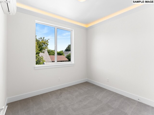 empty room featuring an AC wall unit and carpet flooring