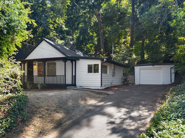 view of front of house featuring a porch, a garage, and an outbuilding