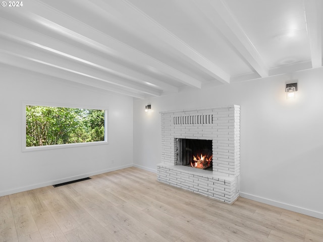 unfurnished living room with beamed ceiling, light wood-type flooring, and a fireplace