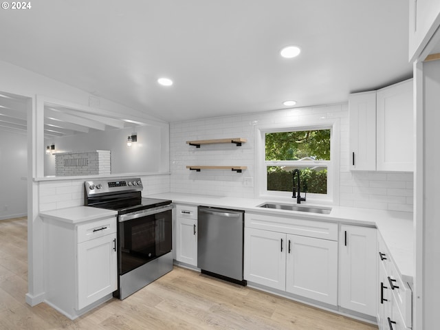 kitchen featuring appliances with stainless steel finishes, light wood-type flooring, sink, and decorative backsplash