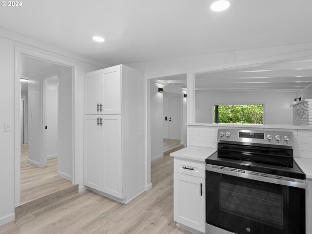 kitchen with backsplash, light wood-type flooring, lofted ceiling with beams, and electric range