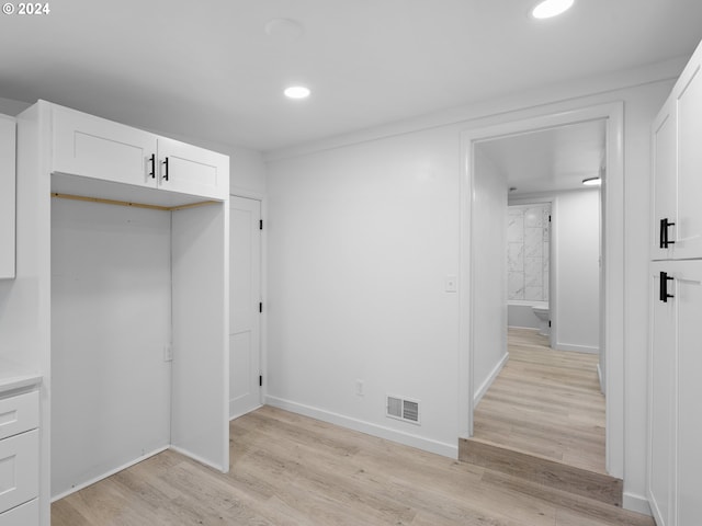 interior space with light hardwood / wood-style flooring and white cabinetry