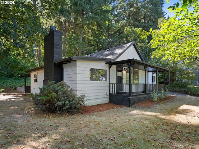 view of side of home featuring covered porch