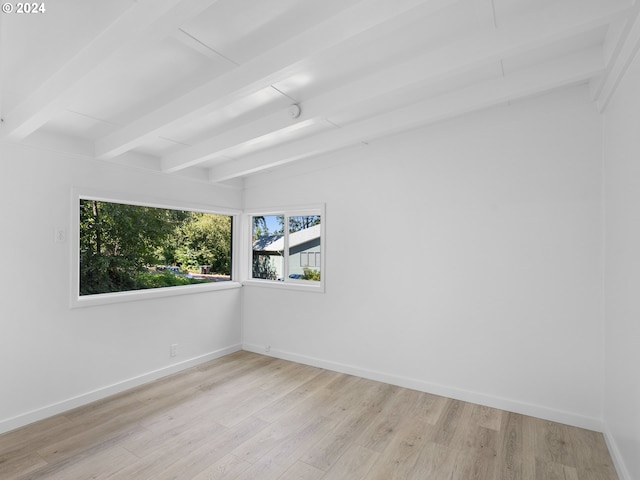 empty room with lofted ceiling with beams and light hardwood / wood-style floors