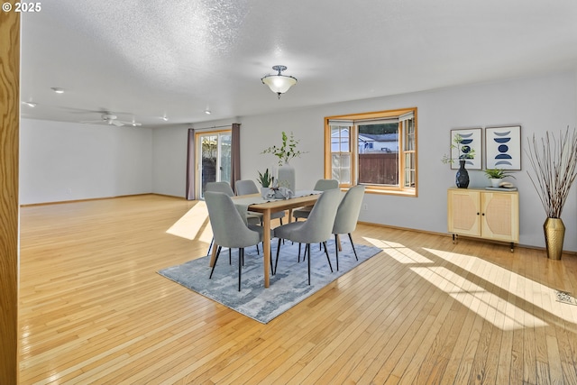 dining space featuring a textured ceiling and light wood-type flooring