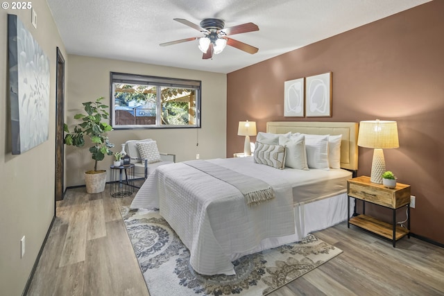 bedroom featuring a textured ceiling, ceiling fan, and light hardwood / wood-style flooring