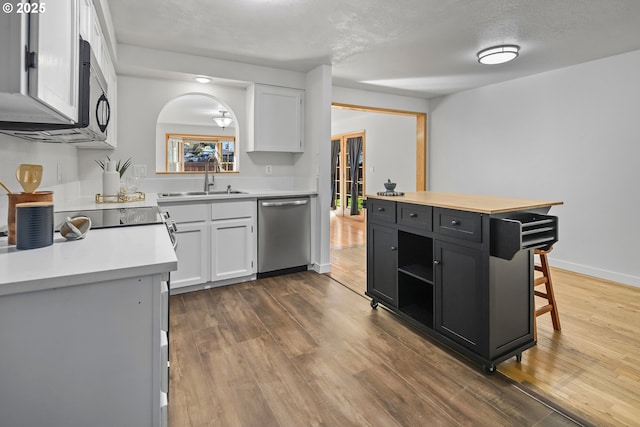 kitchen with sink, a center island, stainless steel dishwasher, and white cabinets