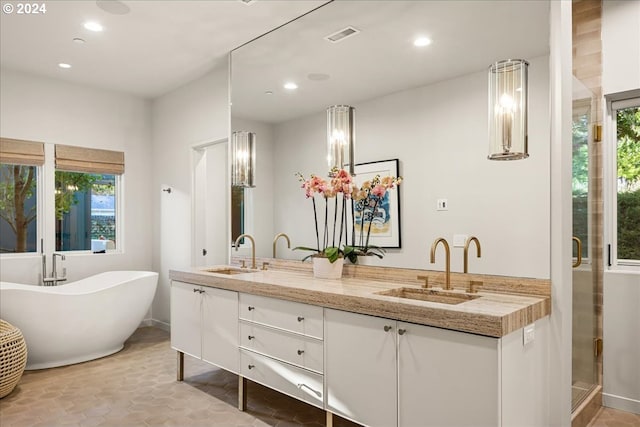 bathroom with vanity and shower with separate bathtub