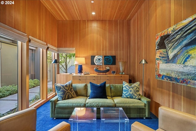 living room featuring dark colored carpet, a towering ceiling, wood ceiling, and wooden walls