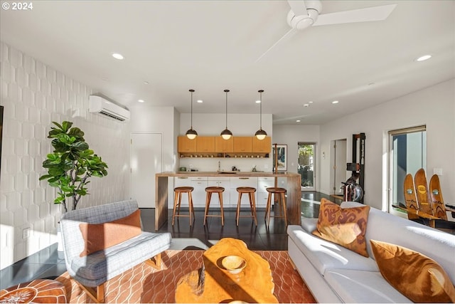 kitchen with ceiling fan, a kitchen bar, light brown cabinetry, and a wall unit AC